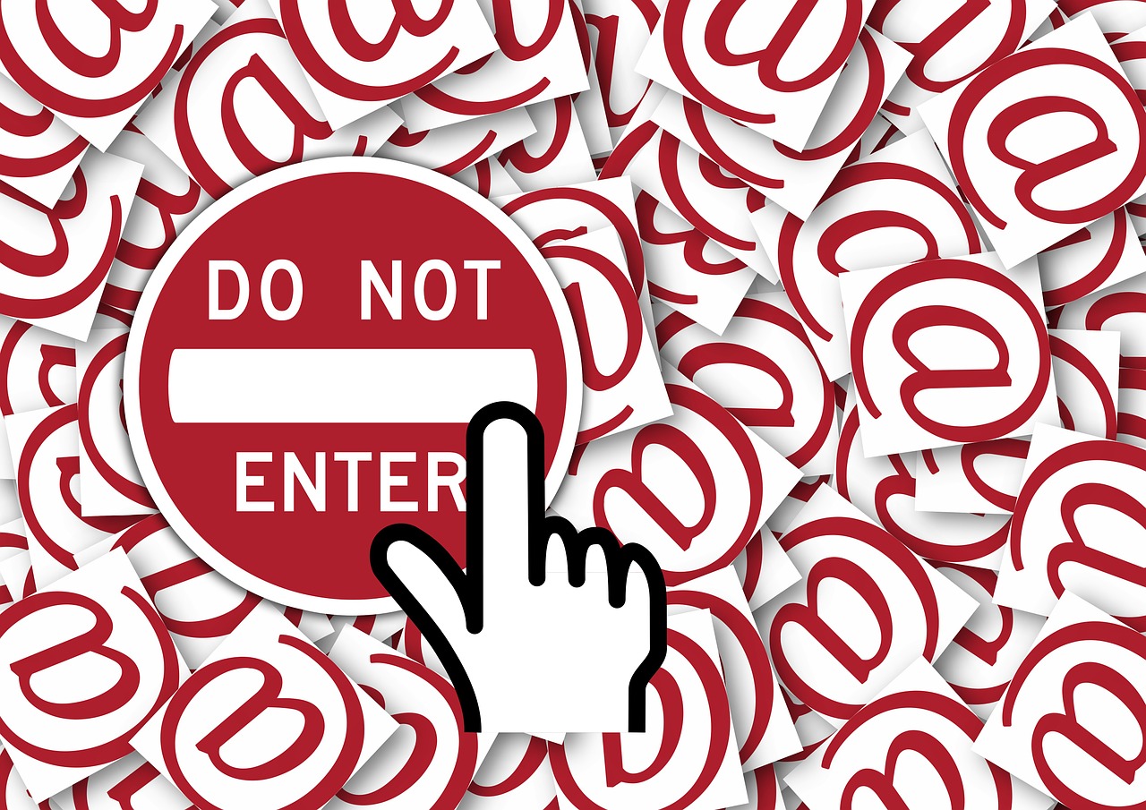 Hand cursor touching a 'Do Not Enter' sign against a field of red '@' symbols