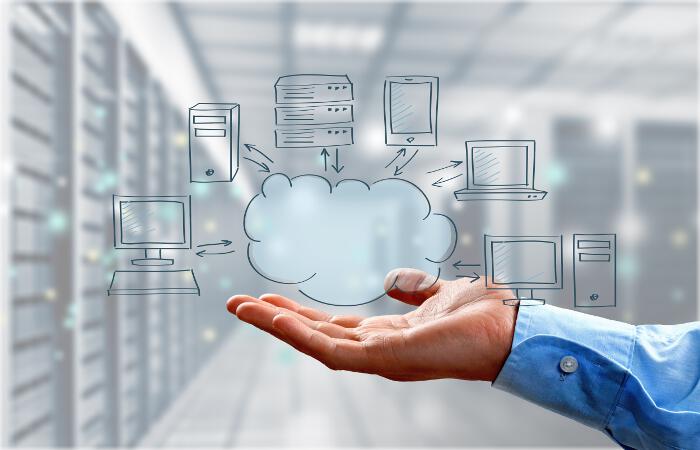 Businessman's Hand Holding Illustration of Cloud Computing Concept in Room with Server Racks on Light Background